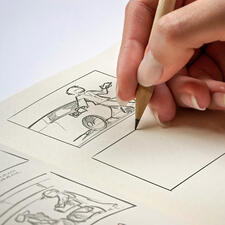 Flex-Book Hand zeichnet in einem Flex-Book mit einem Bleistift.