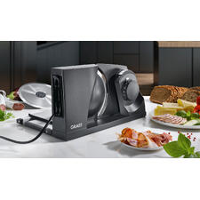 Ultrakompakter Allesschneider - Der weltweit platzsparendste Allesschneider aus Metall. Made in Germany. Ultrakompakter Allesschneider auf einer modernen Küchenarbeitsfläche.