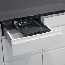 8 cm schmal passt der ultrakompakte Allesschneider sogar in eine Küchenschublade. Ultrakompakter Allesschneider liegt in einer offenen Schublade.