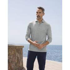 Gris chiné Mann mit grauem Pima-Interlock-Polo, steht vor dem Wasser in der Sonne.