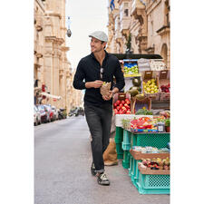Marine Mann mit Bailey of Hollywood Seersucker-Schiebermütze auf Straßenmarkt, hält Tüte mit Essen.