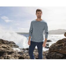 Manches longues, Jean/Écru Mann trägt gestreiftes Langarmshirt und Jeans, steht an der Küste.