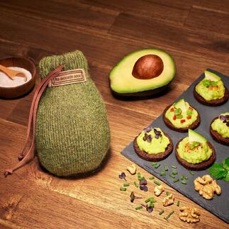 Avocado Sock® zusammen mit Avocado und Snacks auf einem Holztisch.