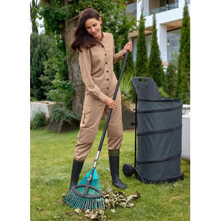 Frau im Garten arbeitet mit einem Rechen.