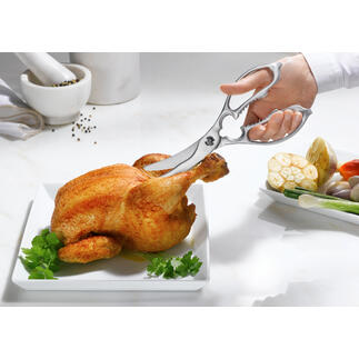Zwei-in-eins Küchen- und Geflügelschere schneidet ein Hähnchen auf einem Teller.