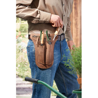 Mann trägt eine Werkzeug-Gürteltasche aus Büffelleder, gefüllt mit Gartenwerkzeugen.