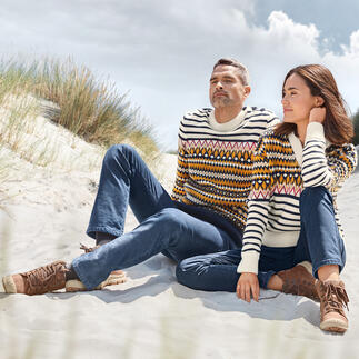 Mann und Frau sitzen auf dem Sand, tragen gestreifte Pullover von Saint James.