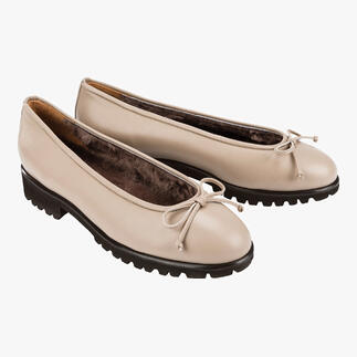 Zwei beige Lammfell-Ballerinas nebeneinander auf hellem Hintergrund.