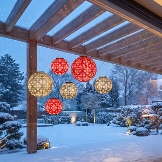 Fünf wetterfeste Lampions in Rot und Grau im Garten bei Schnee.