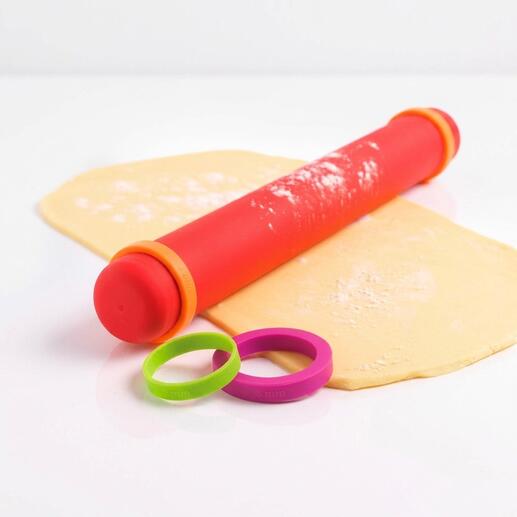 Vario-Teigroller aus Silikon in rot mit abnehmbaren Ringen auf einem Teigblatt.