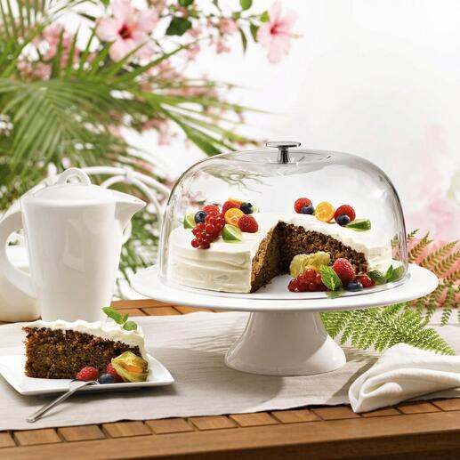 Tortenglocke mit Kuchen und Obst auf einem Tisch