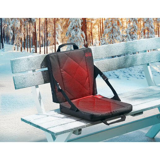 Beheizbare Sitzschale auf einer gefrorenen Parkbank im Winter.