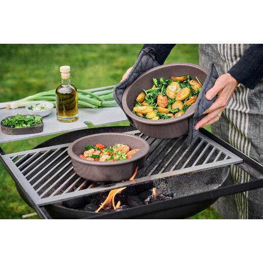 Keltentopf mit Gemüse wird vom Grill genommen.