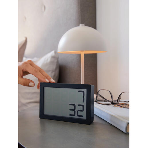 Hand berührt die digitale Tischuhr 