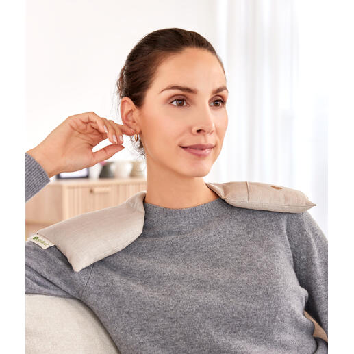 Frau trägt Schulterwärmer und sitzt entspannt auf der Couch