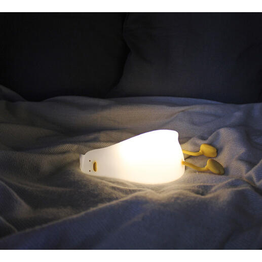 Müde Ente Nachtlicht leuchtet auf einem Bett.