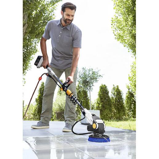 Mann bedient den Twin-Brush Elektro-Schrubber 2.0 auf einem Pflastersteinboden.