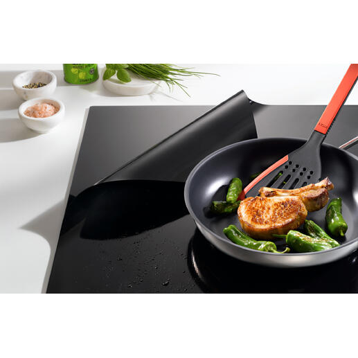 Pfanne mit Zucchini und einem Kotelett auf einem Induktions-Kochfeldschutz