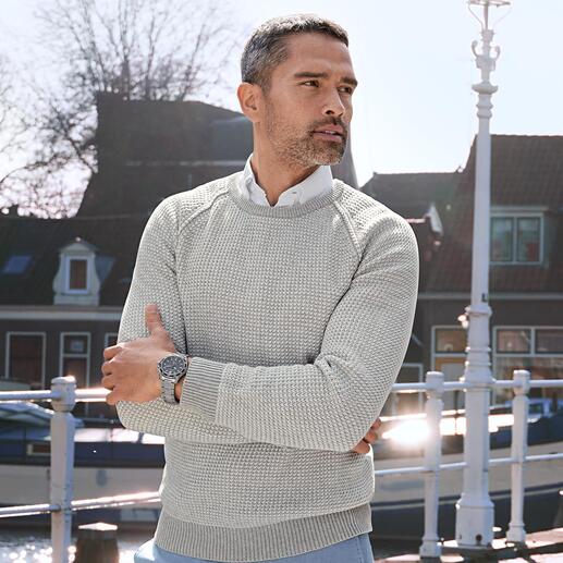 Mann sieht nachdenklich in einen grauen Carbery Patentstrick-Pullover.