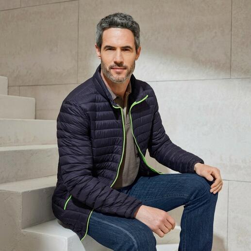 Mann in schwarzer Sommerdaunen-Steppjacke in einem modernen Raum.