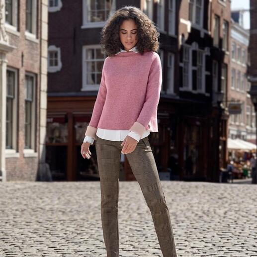 Frau mit rosa Walkpullover auf Pflasterstraße