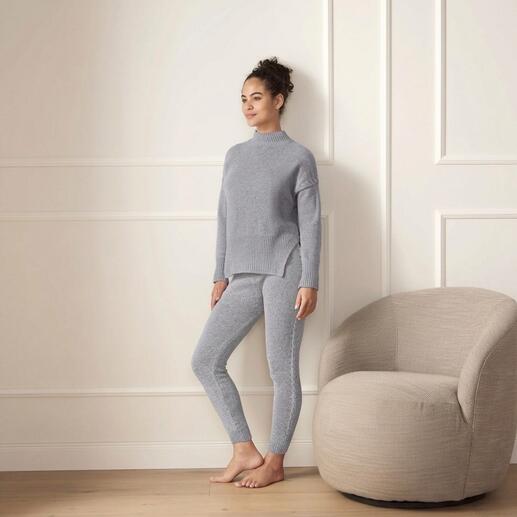 Frau trägt grauen Merino-Pullover und Leggings in einem hellen Raum