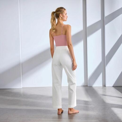 Frau in weißer Sommer-Reisehose, Rückenansicht.
