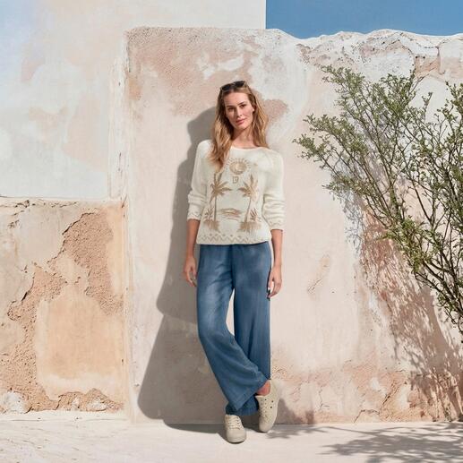 Frau in handbesticktem Frottee-Pullover und weitem Hosen mit Pflanzenmuster