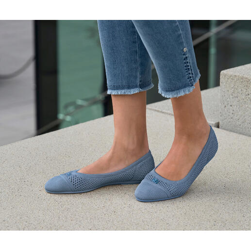 Bleu Frau trägt blaue Mesh-Ballerinas, steht im Freien auf Steinboden.