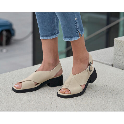 arche Luxus-Komfort-Sandalette Beige arche Sandaletten mit Blockabsatz und Jeans auf einem Steinboden.