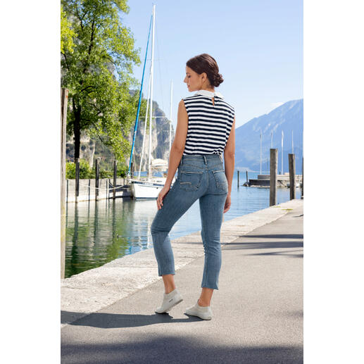 Silver Suki Straight-Jeans Frau in gestreiftem Oberteil und Jeans auf einem Gehweg am Wasser.