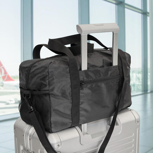 Exklusive faltbare Reisetasche auf einem Koffer im Flughafen.