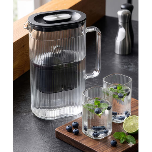 Wasserfilter-Karaffe mit zusätzlichem Glas und frischen Kräutern.