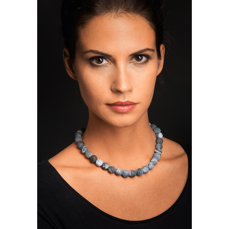 Frau trägt Achat-Collier aus verschiedenen blauen Steinen