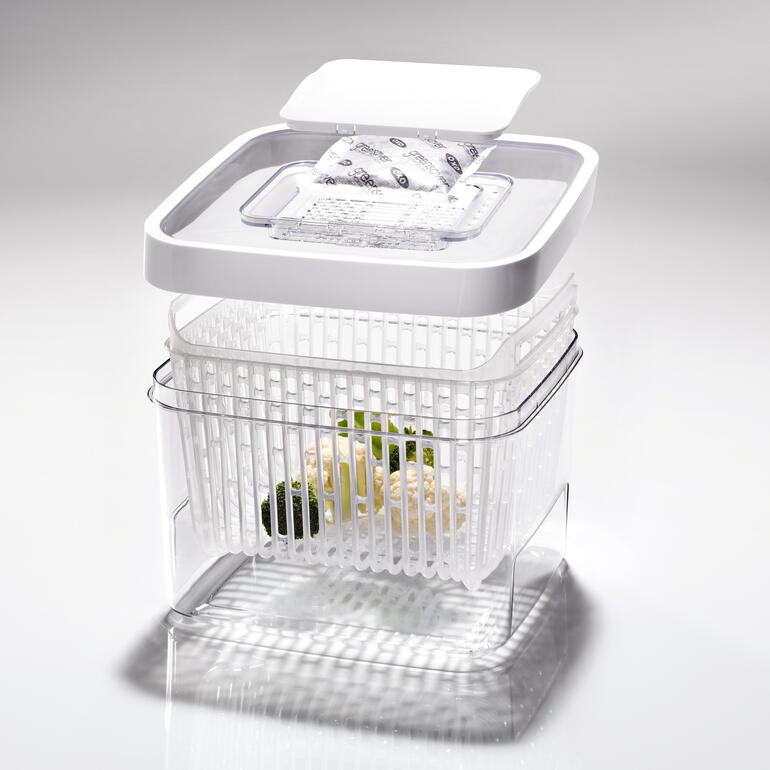 Transparente Frischebox mit grünem Gemüse, gestapelt mit Deckel.