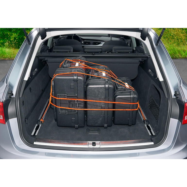 Im Kofferraum eines Autos stabilisierte Koffer mit orangefarbenem Schlaufenseil.
