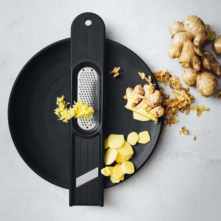 Ingwerreibe 3-in-1 auf einem Teller mit frischem Ingwer.
