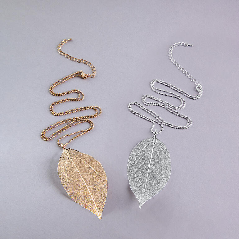 Zwei Ketten mit Blattanhänger in Gold und Silber.