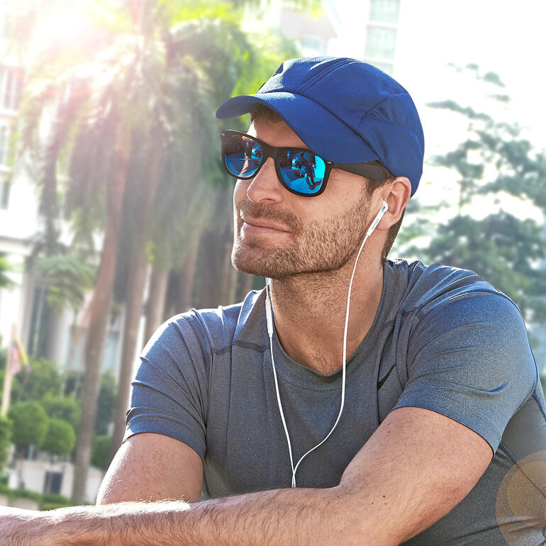 Mann mit Cool Cap und Sonnenbrille, entspannt im Freien.