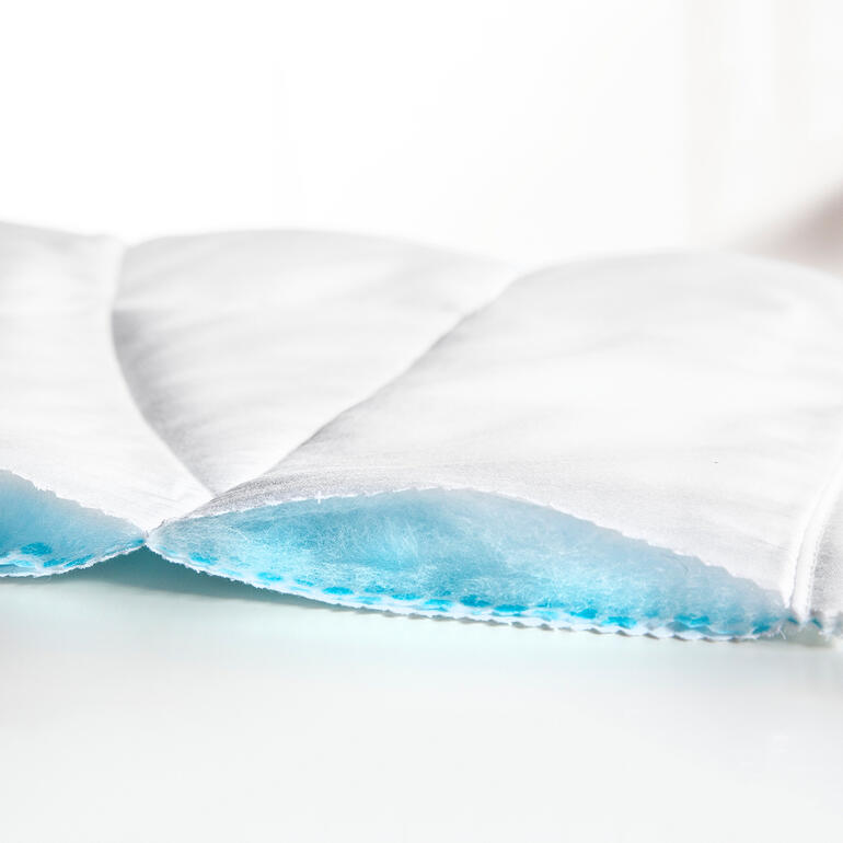 Bezug aus Baumwoll-Satin, Tencel®-Füllung, Vliesseite PCM-Mikrokapseln Detailansicht einer weißen Sommerdecke.