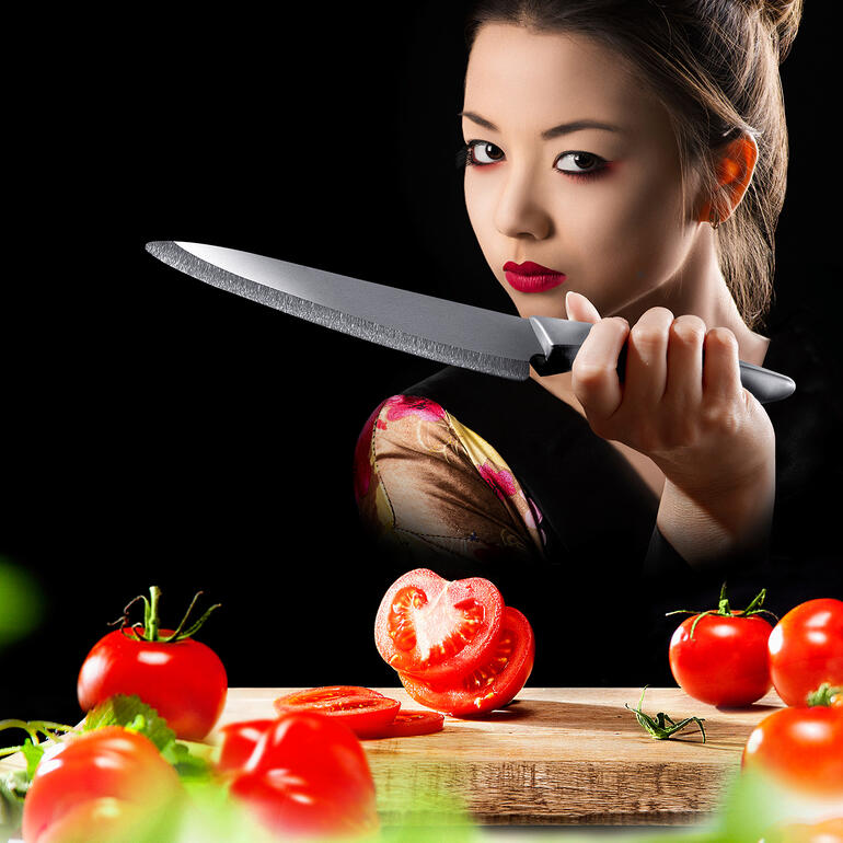 Zirkonia-Keramik-Messer Person mit Zirkonia-Keramik-Messer schneidet frische Tomaten auf einem Holzbrett.