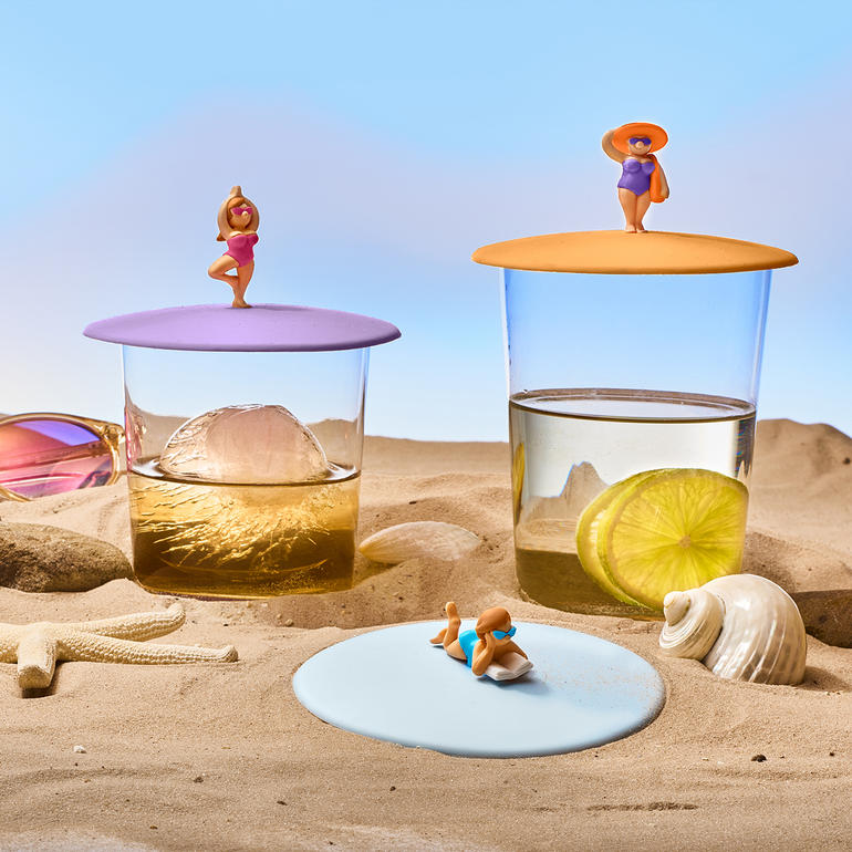 Zwei Glasabdeckungen mit Getränken und einem Strandmotiv.