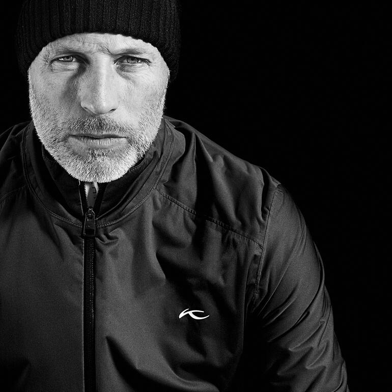 Wende-Funktionskleidung in Schwarz, Modell mit Kapuze.