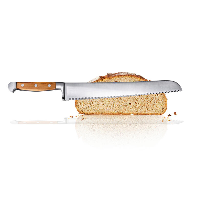 Brotmesser mit Holzgriff und gezahnter Klinge neben einer Brotscheibe.