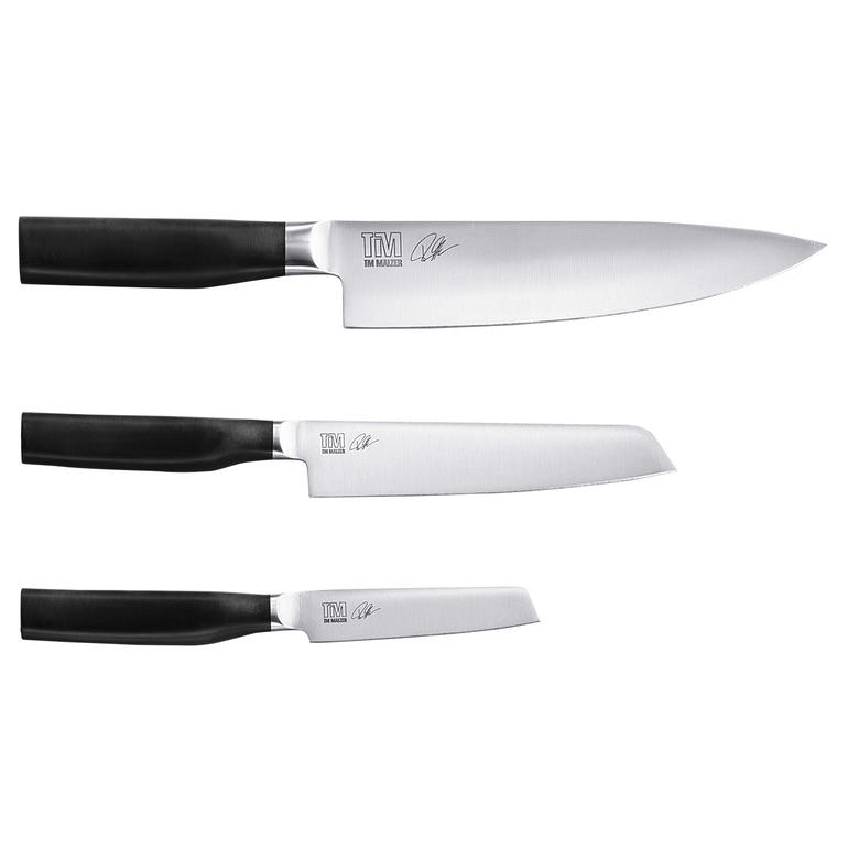 L’équipement de base (disponible en commande séparée) est composé d’un couteau de cuisine, d’un couteau utilitaire et d’un couteau office. Mann mit Kamagata-Messer in der Hand in einem Foodtruck.