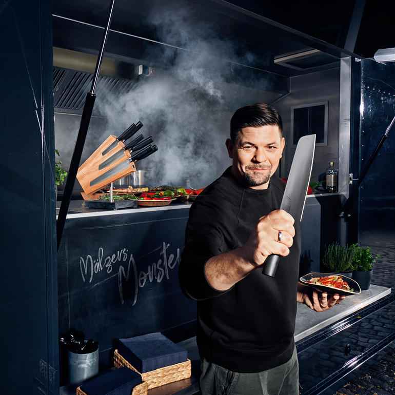 Mann mit Kamagata-Messer in der Hand in einem Foodtruck.