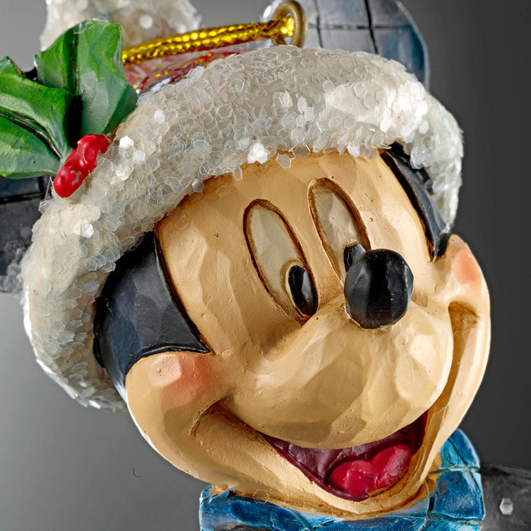 Details von Mickey Mouse mit Weihnachtsmütze und grünem Schal, fröhliches Gesicht.