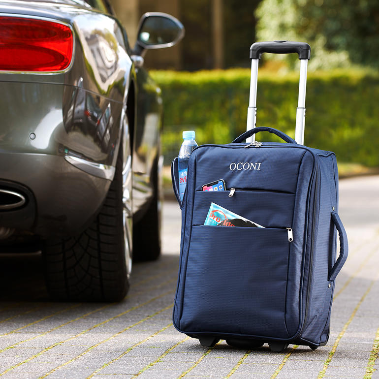 OCONI Falt-Trolley in Dunkelblau mit Rollen, Wasserflasche und Zeitungen in der Tasche.