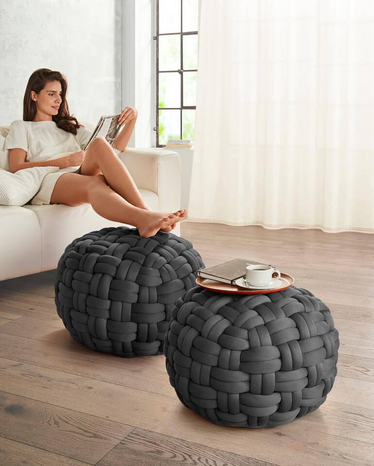 Zwei runde, graue Poufs aus geflochtenem Material im Wohnraum