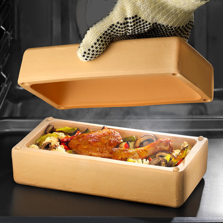 RÖMERTOPF® BBQ Brick mit Hähnchenkeule und Gemüse im Innenraum, Deckel wird angehoben.